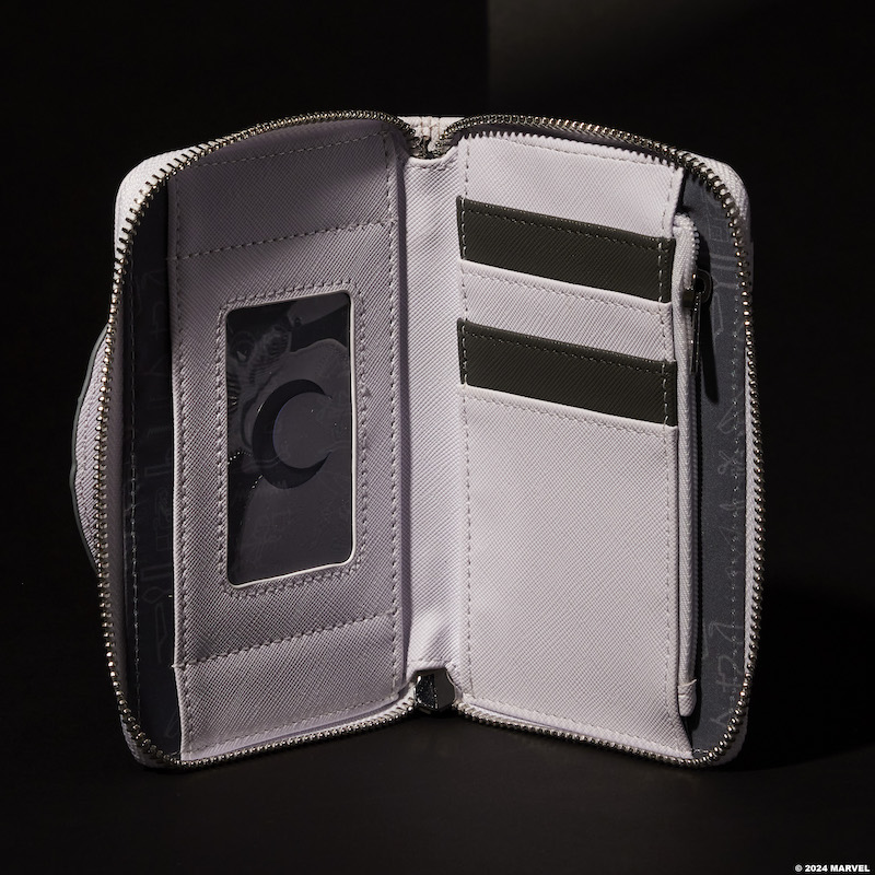 Inside look at the Limited Edition Loungefly Marvel Moon Knight Wallet, featuring four black and white card slots and one clear slot for an ID. The wallet sits against a dark background. 